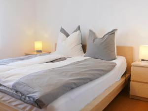 a bed with white sheets and pillows on it at Apartment Buchenhöhe-2 by Interhome in Resten