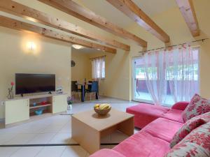 een woonkamer met een roze bank en een tv bij Holiday Home Ljiljana by Interhome in Rakalj