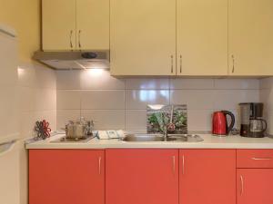een keuken met rode kasten en een spoelbak bij Holiday Home Ljiljana by Interhome in Rakalj +25 foto's