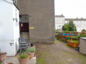 a patio with potted plants on the side of a building at Snug - Sealladh Mara Apartment in Helensburgh