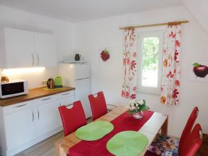 a kitchen with a table and red chairs in a kitchen at Apartment Maier-2 by Interhome in Triberg