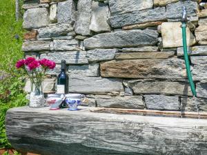 una mesa con jarrones y una botella de vino y flores en Holiday Home Rustico Pamela by Interhome, en Chiavasco