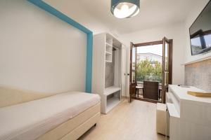 a bedroom with a bed and a bathroom with a sink at Hotel Ristorante La Conchiglia in Cala Gonone