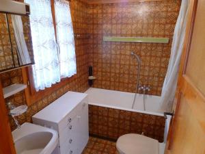 a bathroom with a sink and a tub and a toilet at Apartment Heiderösli-2 by Interhome in Grächen