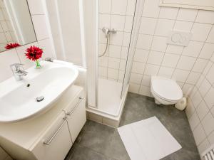 a white bathroom with a sink and a toilet at Apartment smart living by Interhome in Sankt Ulrich