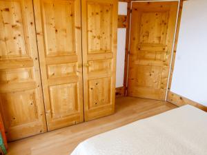 een slaapkamer met houten kastdeuren en een bed bij Apartment Le Bristol C36 by Interhome in Villars-sur-Ollon +19 foto's