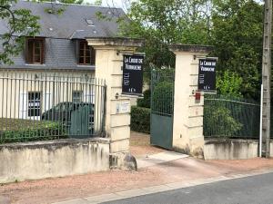 Una puerta a una casa con letreros. en Hotel La Croix De Vernuche en Varennes Vauzelles