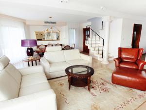 a living room with white furniture and a red chair at Holiday Home Villa Mustra by Interhome in Okrug Donji