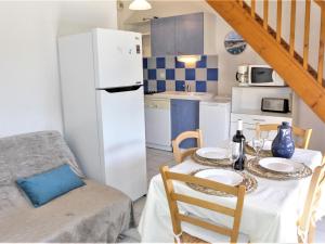 a kitchen with a table and a white refrigerator at Holiday Home Plein Sud by Interhome in Narbonne-Plage +24 photos