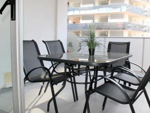 una mesa negra y sillas con una maceta. en Apartment Elegance-14 by Interhome, en Cala de Finestrat