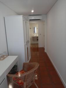 - une cuisine avec un comptoir et une chaise dans une pièce dans l'établissement Casa da Travessa, à Ponte de Lima