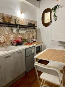 cocina con fregadero y mesa con sillas en Cathedral Sweet home en Palermo