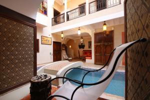 a hotel room with a swimming pool and a chair at Riad Sidi Mimoune & Spa in Marrakech