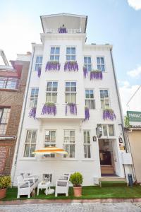 un edificio blanco con flores púrpuras. en Mataraci Konak, en Estambul