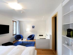 a bedroom with two blue chairs and a desk at Apartment Sternen B by Interhome in Lenk