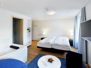 a bedroom with a bed and a table at Apartment Sternen B by Interhome in Lenk