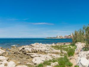 a rocky shore with the ocean and buildings in the background at Apartment Mira-3 by Interhome in Umag