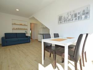 a living room with a table and chairs and a blue couch at Apartment Mira-3 by Interhome in Umag