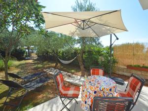 a patio with a table and chairs and an umbrella at Apartment Mira-3 by Interhome in Umag