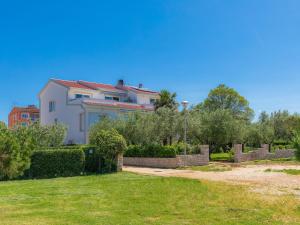 a white house with a fence in a yard at Apartment Mira-3 by Interhome in Umag