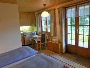 um quarto com uma cama e uma cozinha com uma mesa em Apartment Lohnerhus-2 by Interhome em Grindelwald