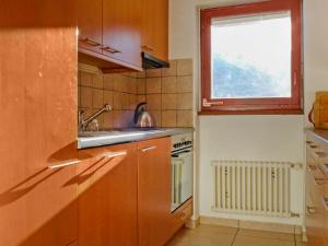 eine Küche mit einer Spüle, einem Herd und einem Fenster in der Unterkunft Apartment Imperial-10 by Interhome in Zermatt