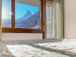 a bedroom with a window with a view of a mountain at Apartment Imperial-10 by Interhome in Zermatt