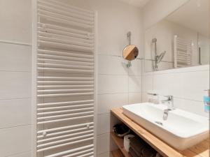 a white bathroom with a sink and a mirror at Apartment Stöcklhof-1 by Interhome in Pettneu am Arlberg