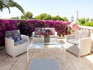 um pátio com três cadeiras e uma mesa com um vaso de flores em Villa Cathy & Marianne by Interhome em Casas de Torrat