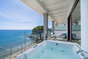 a bathtub in a house with a view of the ocean at Hotel Ristorante La Conchiglia in Cala Gonone