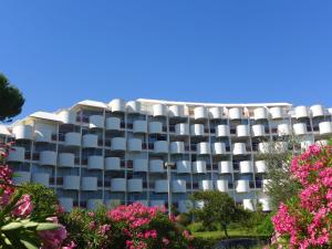 un immeuble avec des balcons blancs et des fleurs roses dans l'établissement Apartment Cap Sud-3 by Interhome, à La Grande Motte