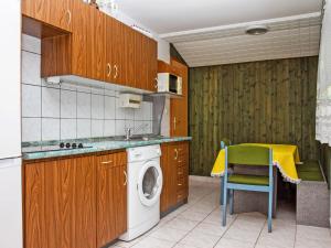 eine Küche mit einer Waschmaschine und einem Stuhl darin in der Unterkunft Holiday Home Azzurro by Interhome in Balatonmáriafürdő