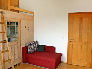 een rode stoel in een kamer met een deur bij Holiday Home große Winten by Interhome in Geinberg +23 foto's