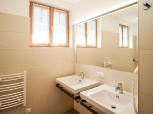 a white bathroom with a sink and a mirror at Apartment Gipfelkreuz by Interhome in Donnersbachwald