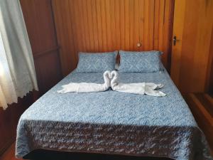 uma cama com duas pessoas de toalha deitadas nela em Casa de Ferias Dona Inês em Treze Tílias