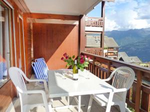 een witte tafel en stoelen op een balkon bij Studio Sources 4109 by Interhome in Ovronnaz +10 foto's