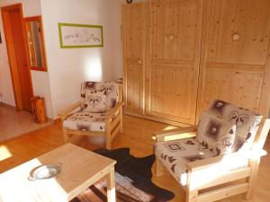 a living room with two chairs and a table at Studio Sources 4109 by Interhome in Ovronnaz