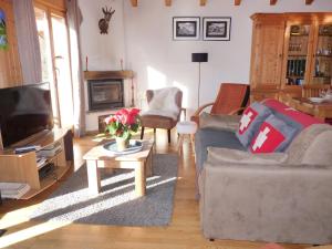 a living room with a couch and a tv at Chalet Ropiar by Interhome in Ovronnaz