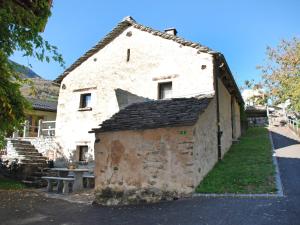 um velho edifício de pedra com um banco em frente em Holiday Home Rustico Cristallo by Interhome em Aquila