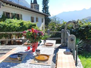 a table with plates of food and flowers on it at Holiday Home Rustico Cristallo by Interhome in Aquila