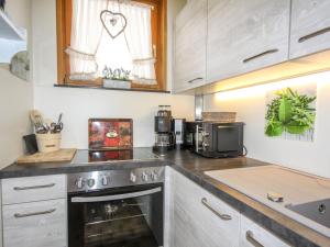 a kitchen with a stove and a microwave at Apartment Holiday-5 by Interhome in Zell am See