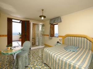 a bedroom with a bed and a table and a window at La Locanda Del Fiordo in Furore