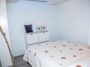 a white room with a bed with flowers on it at Holiday Home Melograno by Interhome in Landarenca