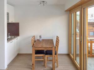 een keuken met een houten tafel en stoelen bij Studio Grenier 5 by Interhome in Nendaz