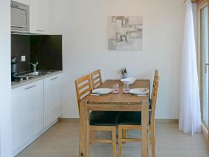 a dining room table with chairs and a kitchen at Studio Grenier 5 by Interhome in Nendaz
