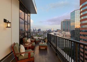 a balcony with chairs and tables and a view of a city at Hutton Hotel in Nashville