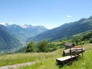 a bench on a hill with mountains in the background at Holiday Home Baita Ficc by Interhome in Leontica