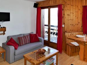 a living room with a couch and a table at Apartment Foret E3 by Interhome in Nendaz