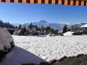 a snow covered ground with mountains in the background at Apartment Cristel 2 by Interhome in Villars-sur-Ollon