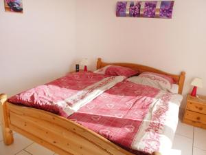 een slaapkamer met een bed met een rode en witte deken bij Apartment Ardévine 5 by Interhome in Ovronnaz